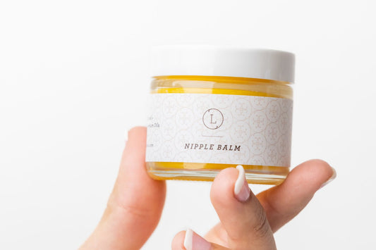 Natural organic nipple balm in a smal jar - held in a hand